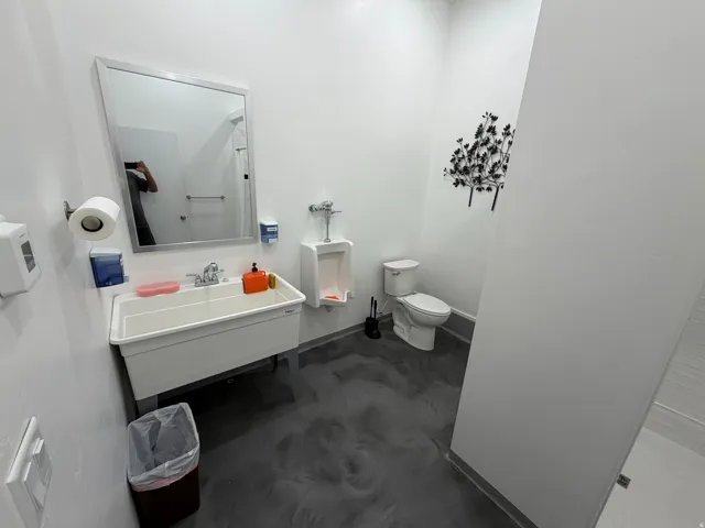 Shop bathroom complete with urinal, shower and wall-mounted sink.