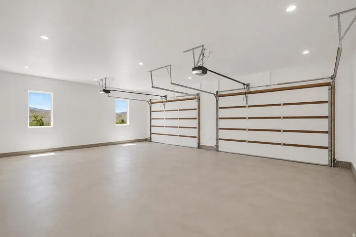 Spacious two-car garage featuring automatic openers, recessed lighting, and dual windows