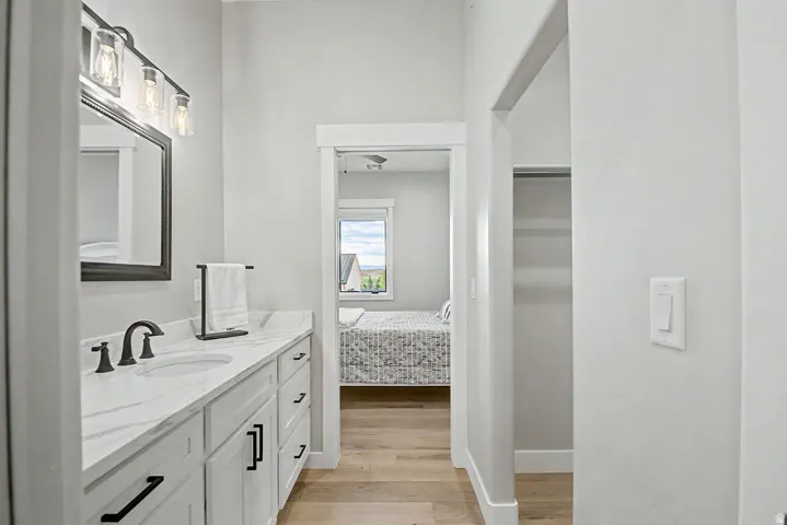 Vanity with oval undermount sink, quartz countertop, and matte black fixtures