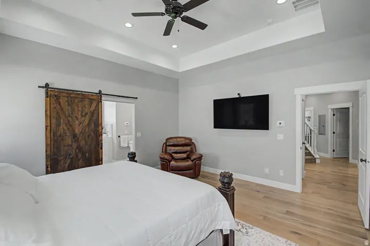 Spacious room featuring Hallmark Orris Maple  flooring, a coffered ceiling with recessed lighting, and a ceiling fan