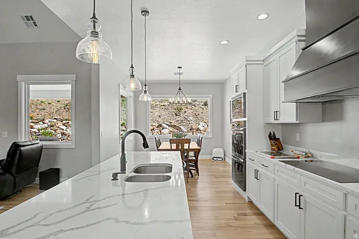 Open-concept kitchen featuring an expansive island with a dual-basin sink and modern faucet