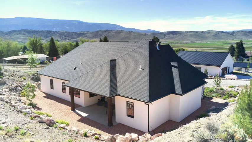 White stucco exterior with a dark asphalt shingle roof