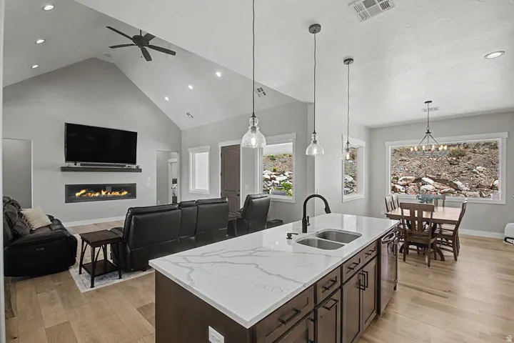 Spacious open-concept living area featuring a vaulted ceiling and Hallmark Orris Maple   flooring
