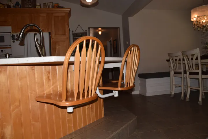 Kitchen island with wood paneling, light countertop, and integrated seating