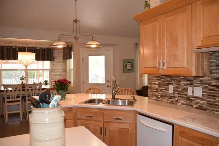 Expansive kitchen featuring light-toned cabinetry, a mosaic tile backsplash, and light-colored countertops