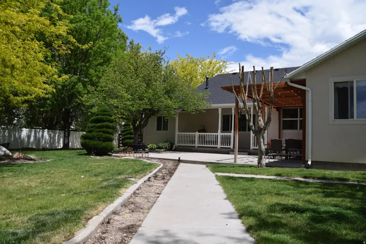 Expansive backyard featuring a concrete patio with an attached pergola