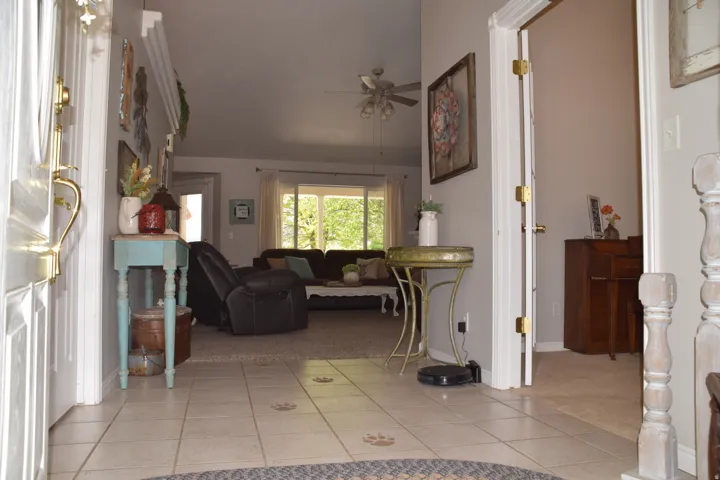 Tiled entryway featuring a decorative light fixture and access to interior spaces