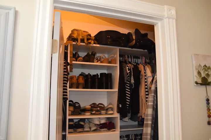Custom closet organization system featuring built-in shelving and hanging rods