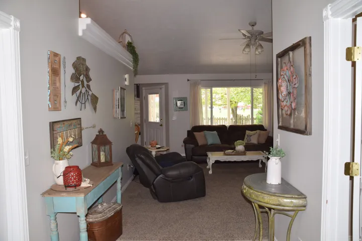 Open concept living area with light gray wall paint and neutral carpet flooring