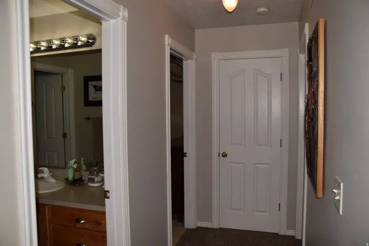 Hallway featuring light gray walls, white trim, and a ceiling-mounted light fixture