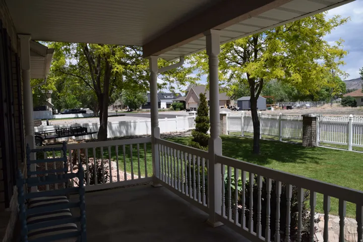 Covered front porch with white baluster railing and columns