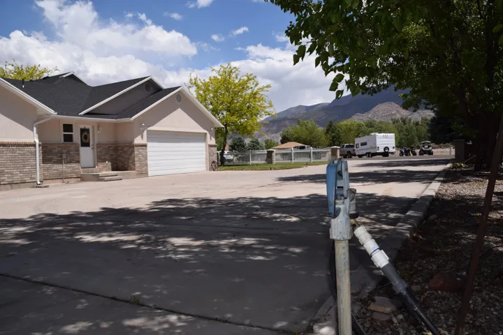 Single-story exterior with a two-car garage and a light stucco finish, complemented by a brick wainscoting