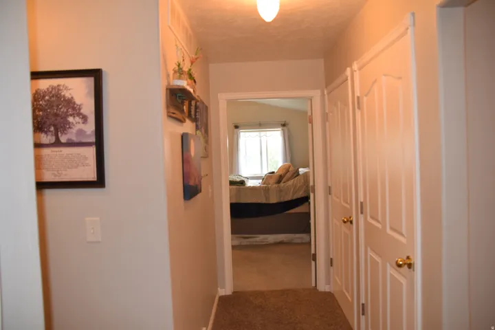 Hallway featuring light-toned wall paint and overhead lighting