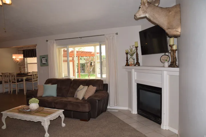 Living area featuring a white mantel, built-in fireplace, and sliding glass door