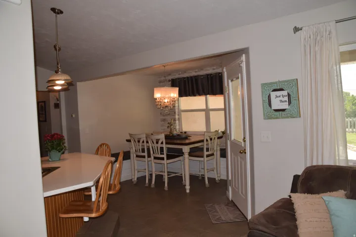 Dining area with chandelier lighting and a window-side built-in bench seating
