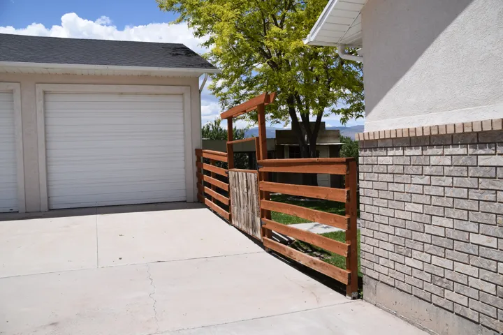 Concrete driveway leading to a two-car garage with white roll-up doors
