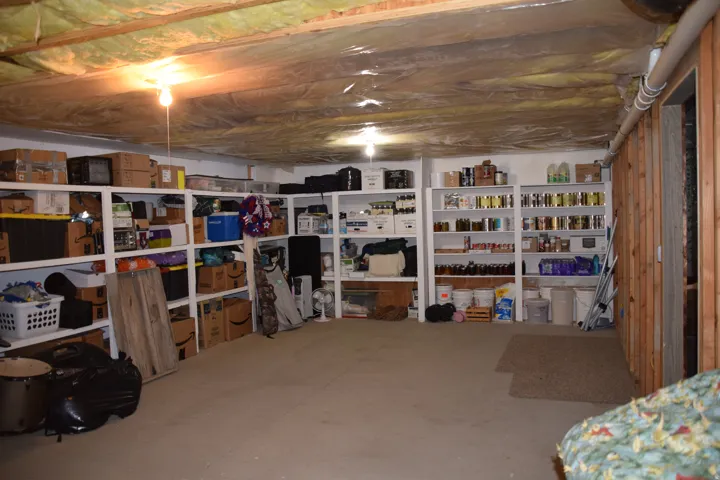Unfinished basement with concrete flooring and exposed ceiling joists