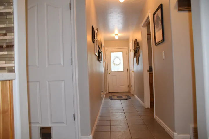 Entryway featuring tile flooring, neutral wall tones, a white paneled door, and a frosted glass front door