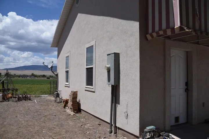 Stucco exterior with multiple windows and a side entry door