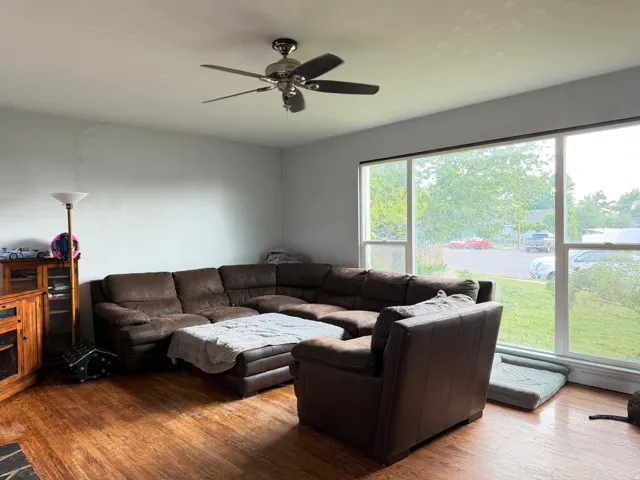 Living area with hardwood flooring and a ceiling fan