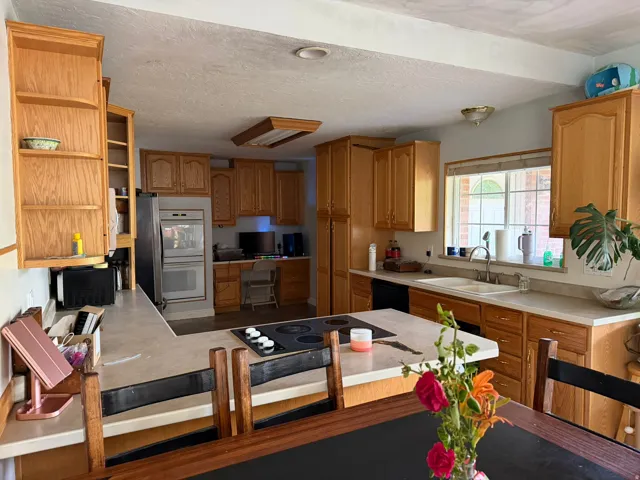 Kitchen featuring wood cabinetry, light countertops, and a window above the sink