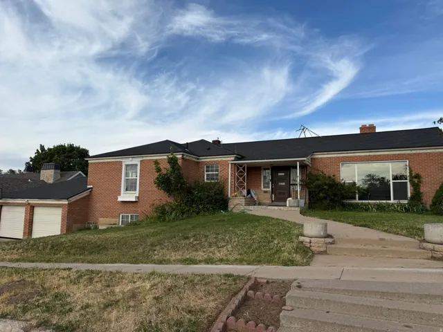 Brick exterior residence with a covered front entry, an attached two-car garage, and a large picture window