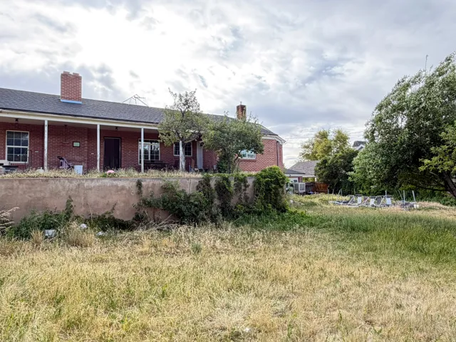 Brick exterior with a covered porch, terraced yard