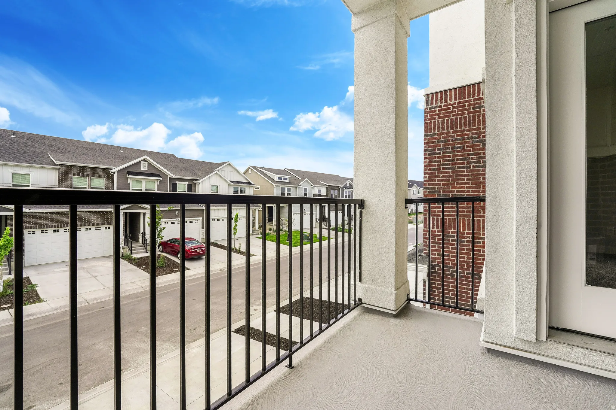 Private balcony featuring sturdy black metal railings and a textured concrete surface