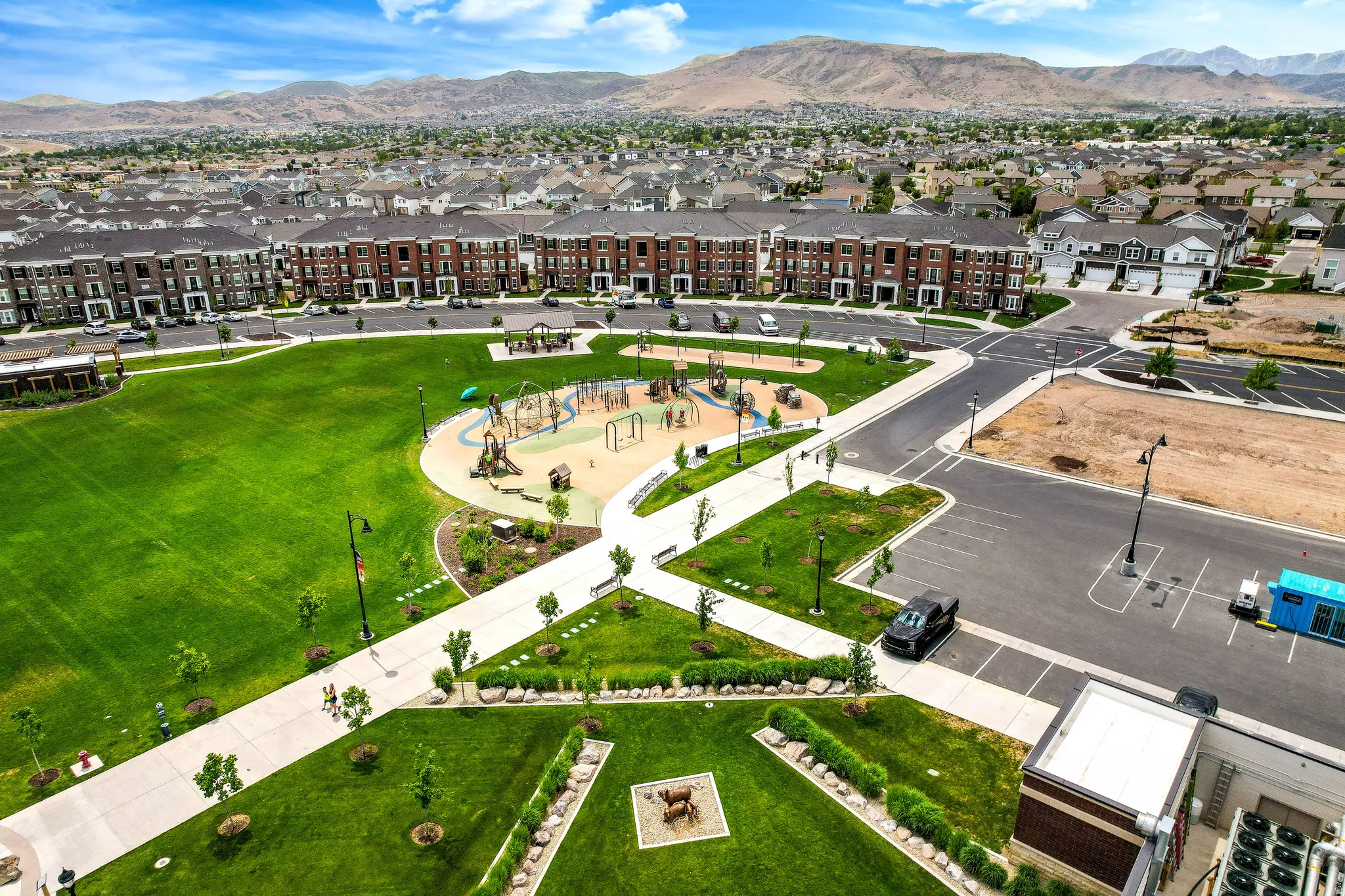 Expansive green space with a playground, paved walking paths, and mature landscaping