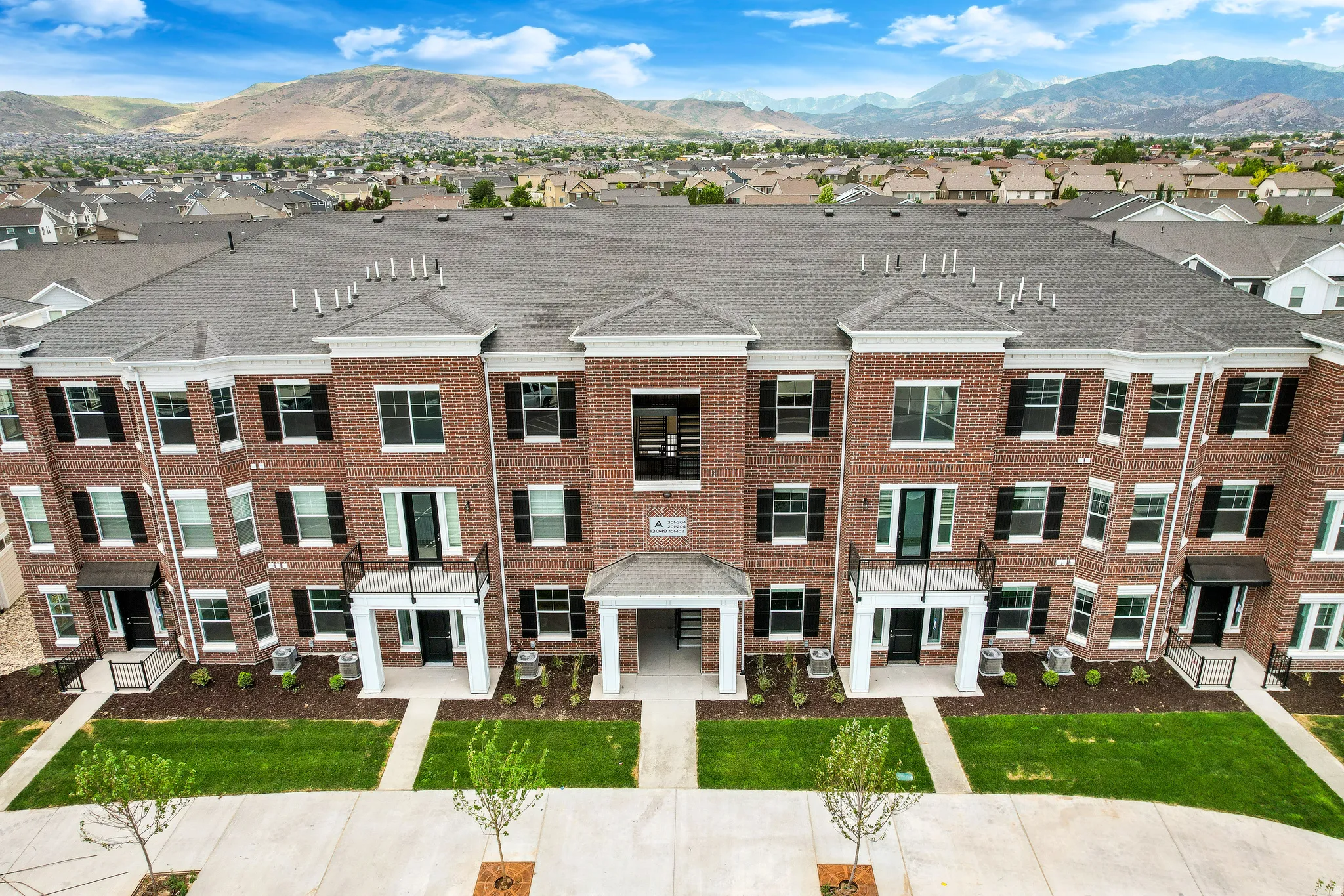 Multi-story brick facade property with white trim accents and black shutters
