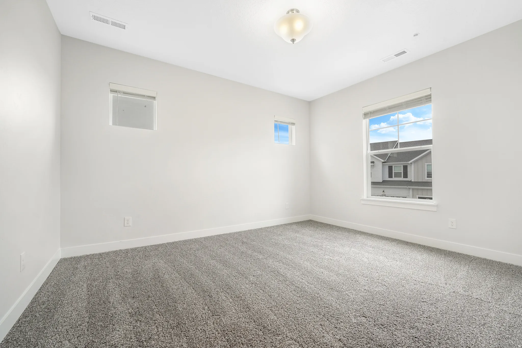 Neutral-toned interior room featuring light gray walls and plush gray carpeting