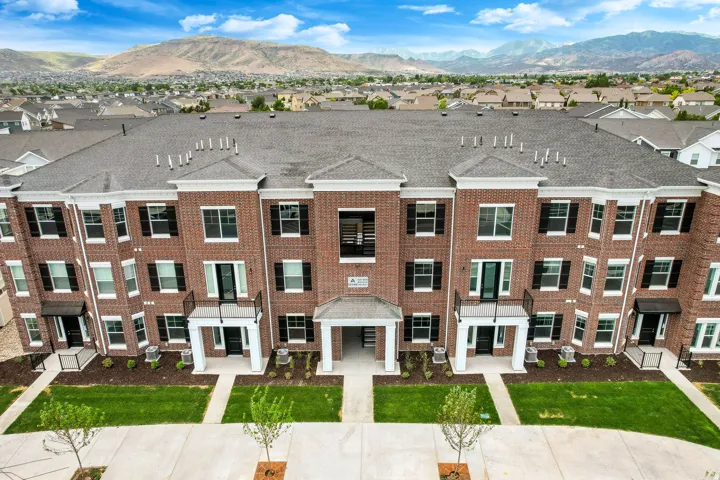Multi-story brick facade property with white trim accents and black shutters