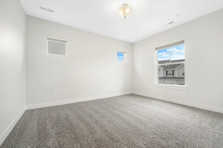 Neutral-toned interior room featuring light gray walls and plush gray carpeting
