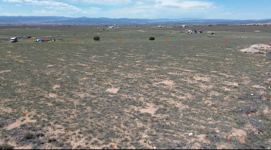 Expansive land parcel featuring natural ground cover and distant mountain ranges