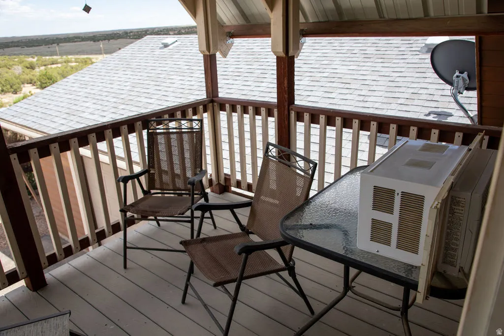 Covered balcony featuring wood railing and wood-finish decking
