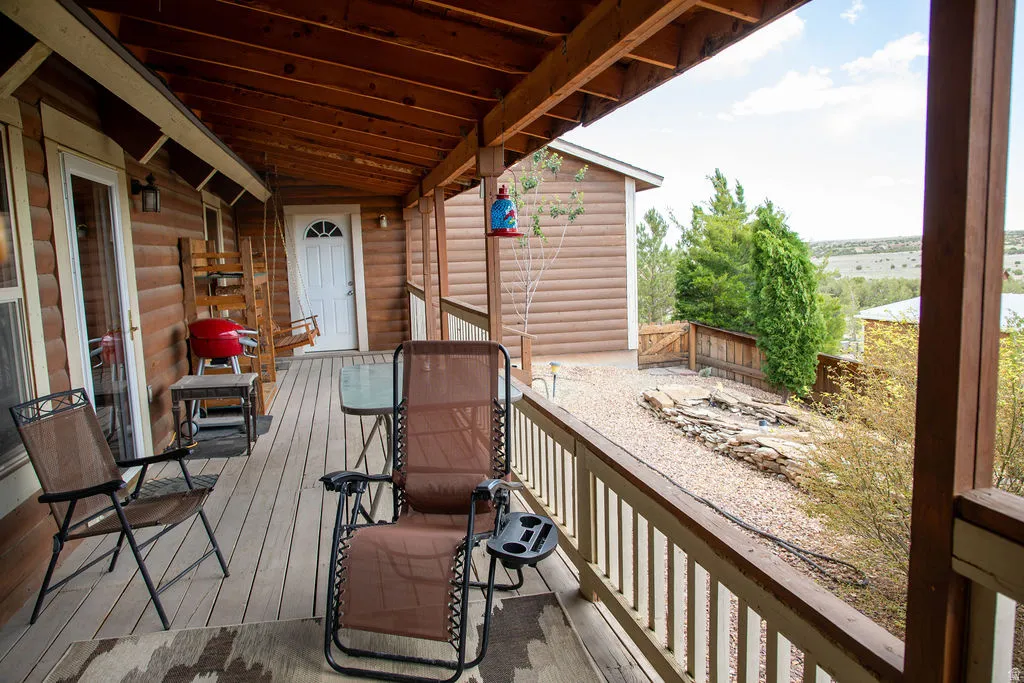 Expansive covered porch featuring a wood-plank floor and a wood-slat ceiling
