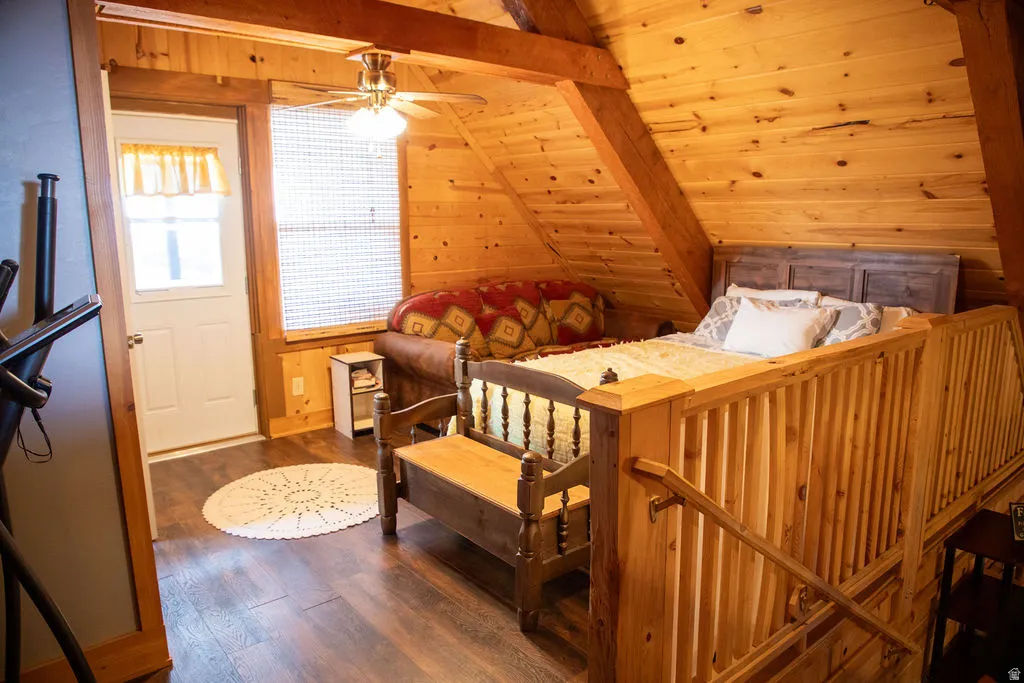 Wood-paneled room featuring exposed wood beams and wood-finish flooring