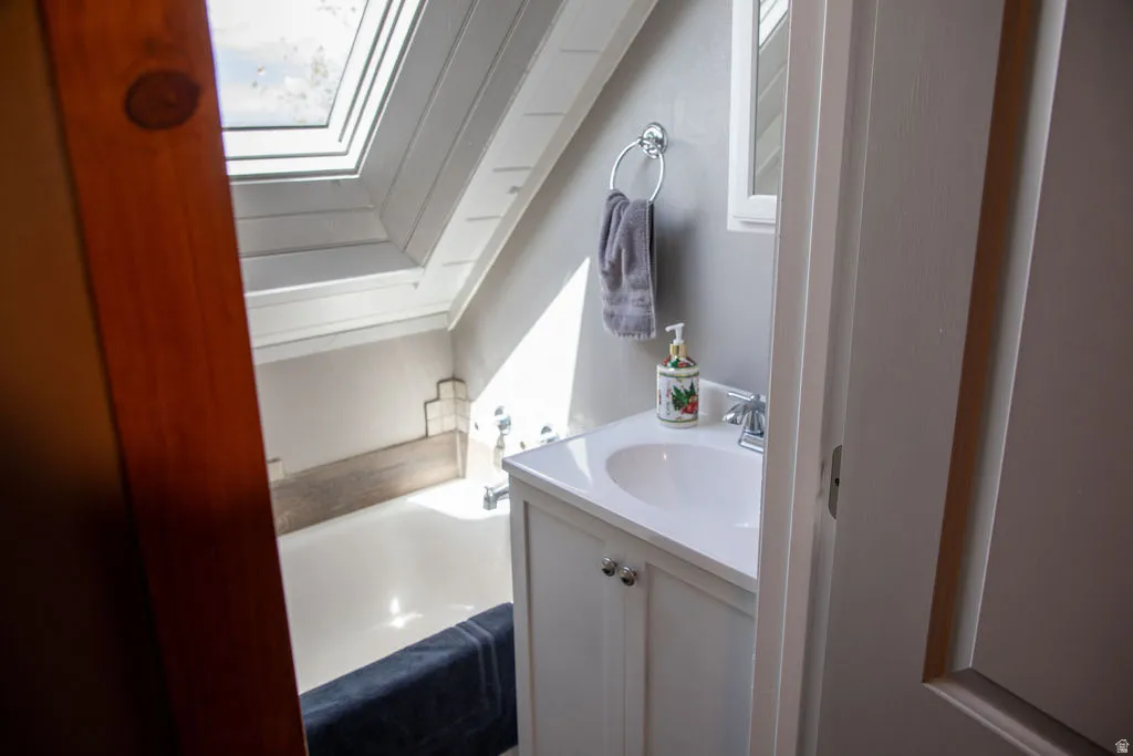 Bathroom featuring a white vanity with integrated sink, chrome faucet, and mirrored medicine cabinet