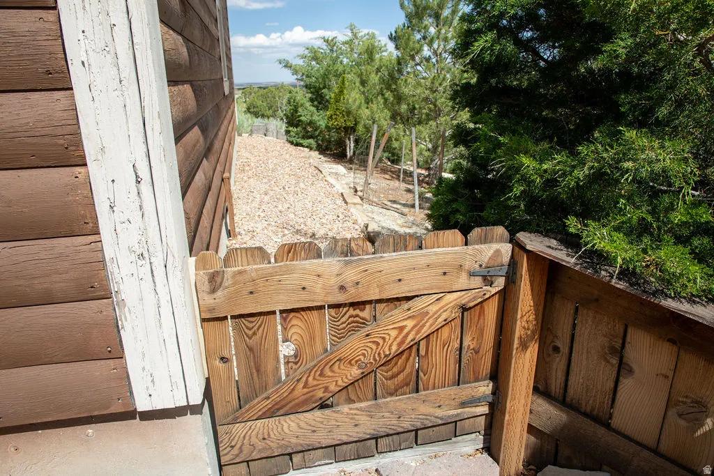 Wood-paneled siding exterior featuring a wooden privacy fence and gate