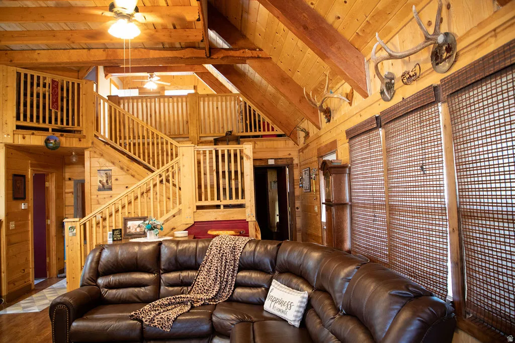 Spacious interior featuring natural wood-finish walls and ceilings, exposed wood beams, and a multi-level staircase with wood railings