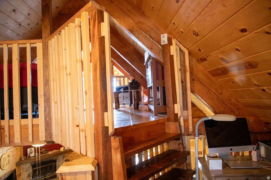 Wood-paneled interior with exposed wood beams and sloped ceilings