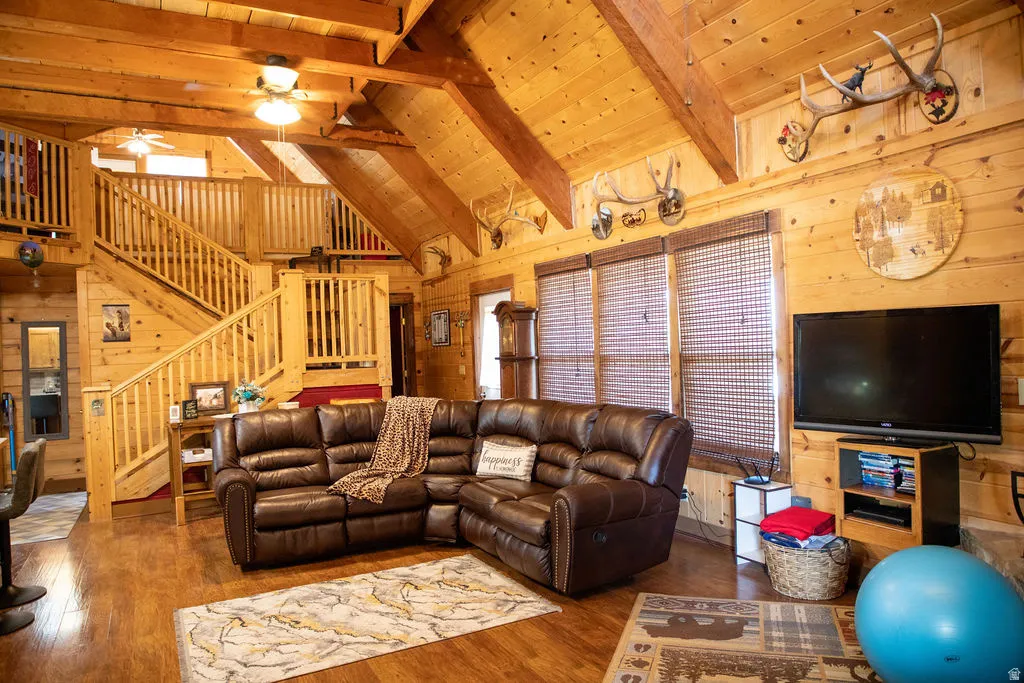 Spacious living area featuring extensive wood paneling and exposed wood beam ceilings