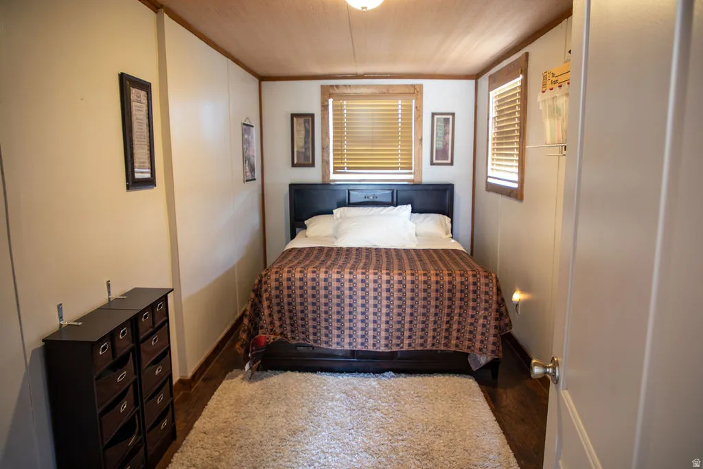 Interior space featuring wood-finish flooring, white panel walls, and a wood-paneled ceiling