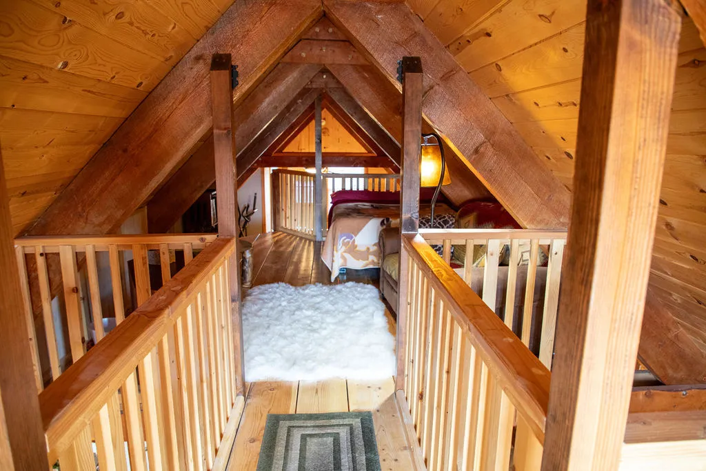 Upper-level loft space featuring exposed wood beams and wood-finish flooring