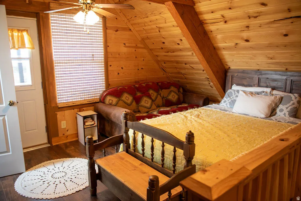 Wood-paneled room featuring a sloped ceiling and exposed wood beam