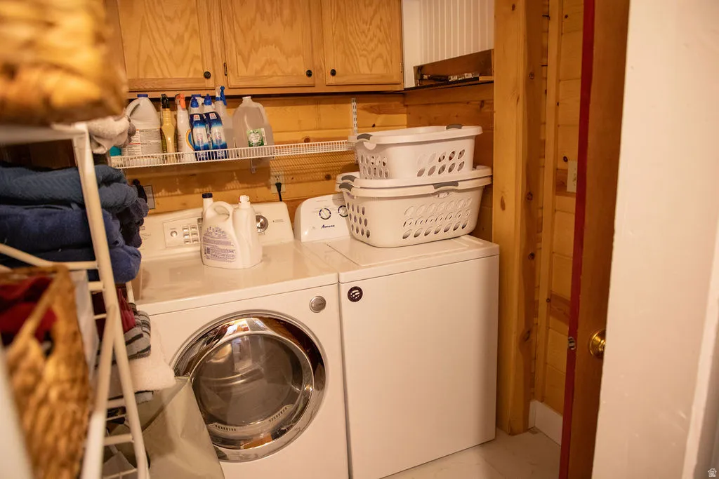 Dedicated laundry area featuring wood-finish wall paneling and built-in wood cabinetry