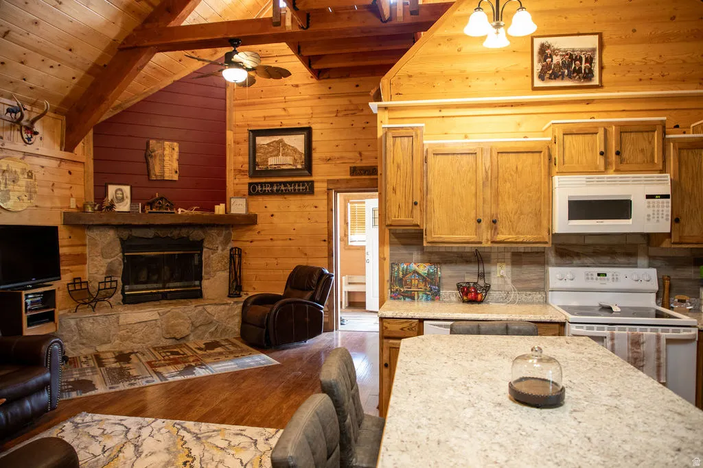 Open-concept living space featuring a stone-clad fireplace and wood-finish flooring