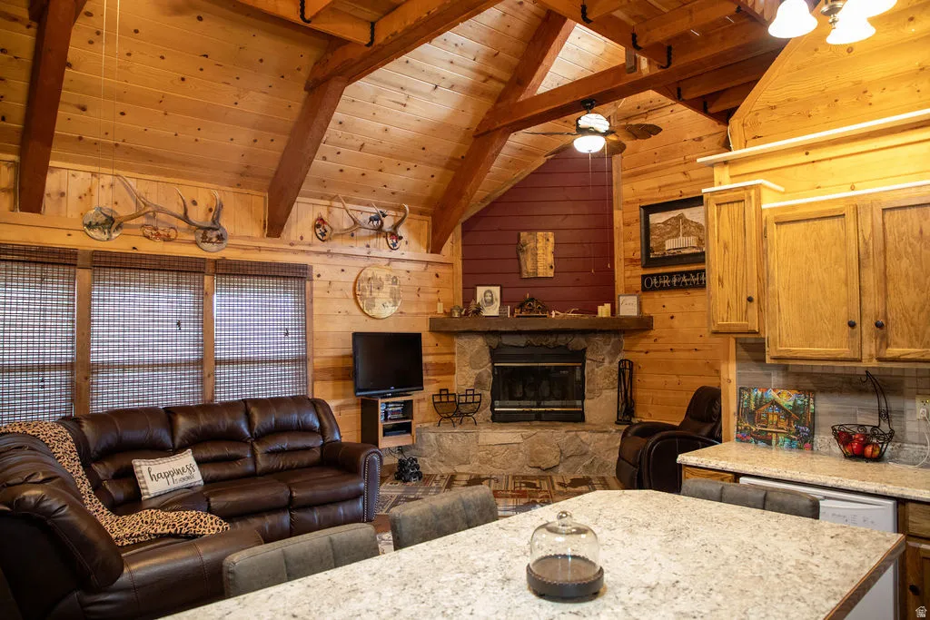 Wood-paneled interior featuring a vaulted wood-beam ceiling, stone-faced fireplace, and wood-finish cabinetry