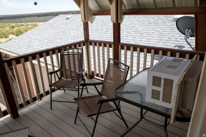Covered balcony featuring wood railing and wood-finish decking