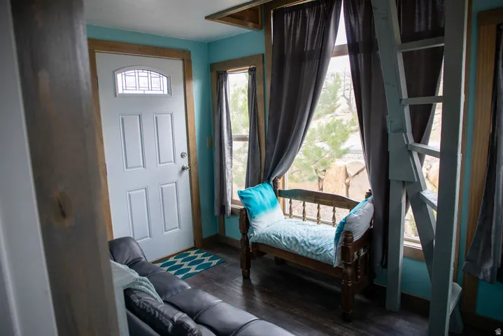 Entry area featuring a four-panel door with an arched transom window, wood-finish flooring, and light blue wall tones